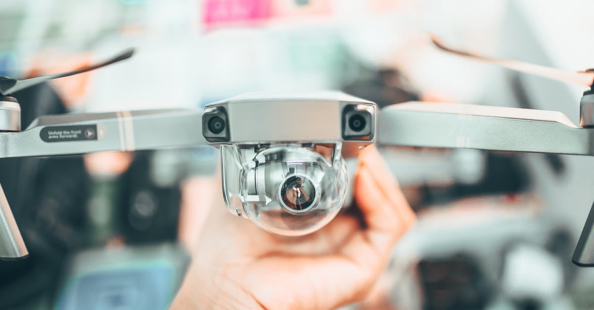 What command can I use to detect when a minecraft record ends? - Crop unrecognizable person holding modern drone in hand and demonstrating camera against blurred interior background