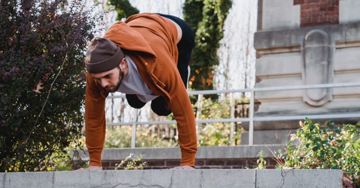 What could cause power to go down just by moving? - Serious male athlete standing on arms upside down while doing parkour in urban environment What could cause power to go down just by moving? - Serious male athlete standing on arms upside down while doing parkour in urban environment