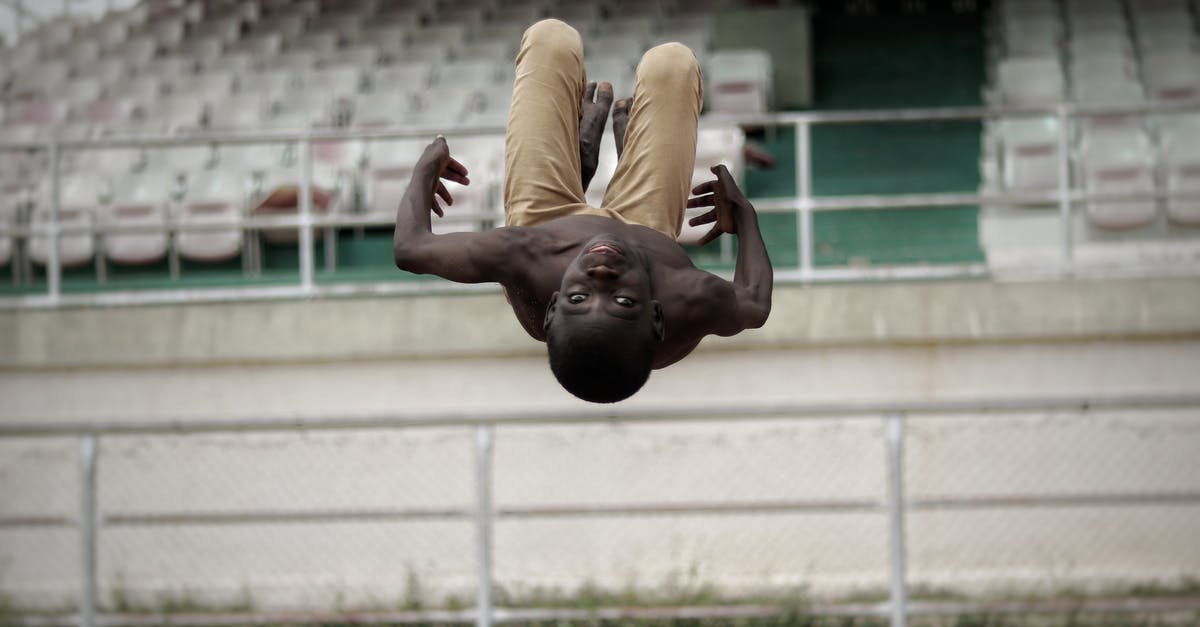 What could cause power to go down just by moving? - African American man practicing parkour stunts in stadium and doing flip with head down What could cause power to go down just by moving? - African American man practicing parkour stunts in stadium and doing flip with head down