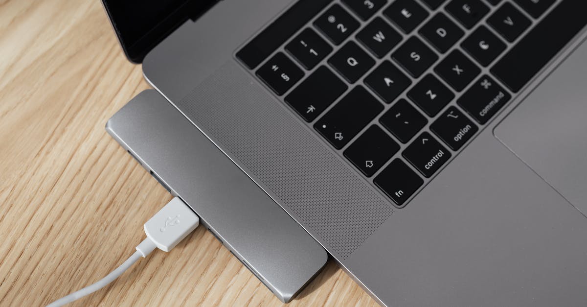 What could possibly this CP Multiplier be related to? - From above of gray colored contemporary netbook with usb port multiplier and white cable connected to usb hub on wooden table