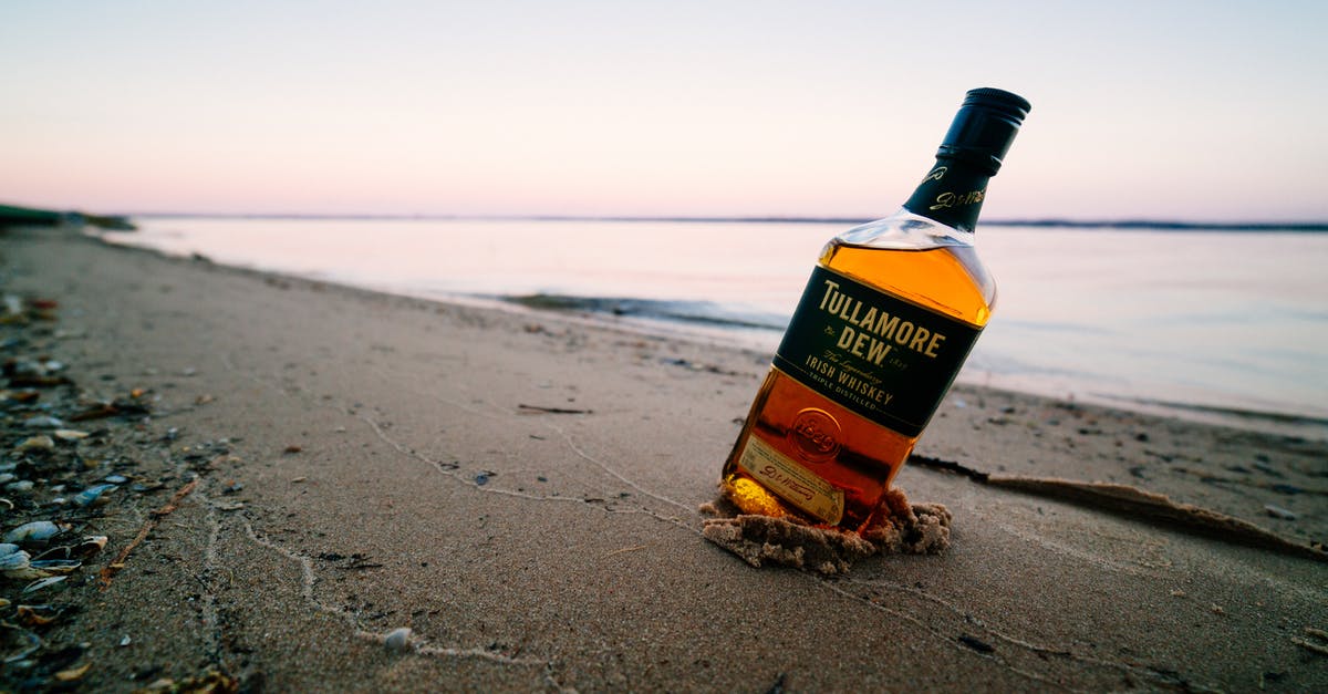What counts as strong alcohol for potion refilling? - Ground level of strong elite alcoholic drink in transparent glass bottle on wet sandy shore near calm endless ocean under sky at sunset