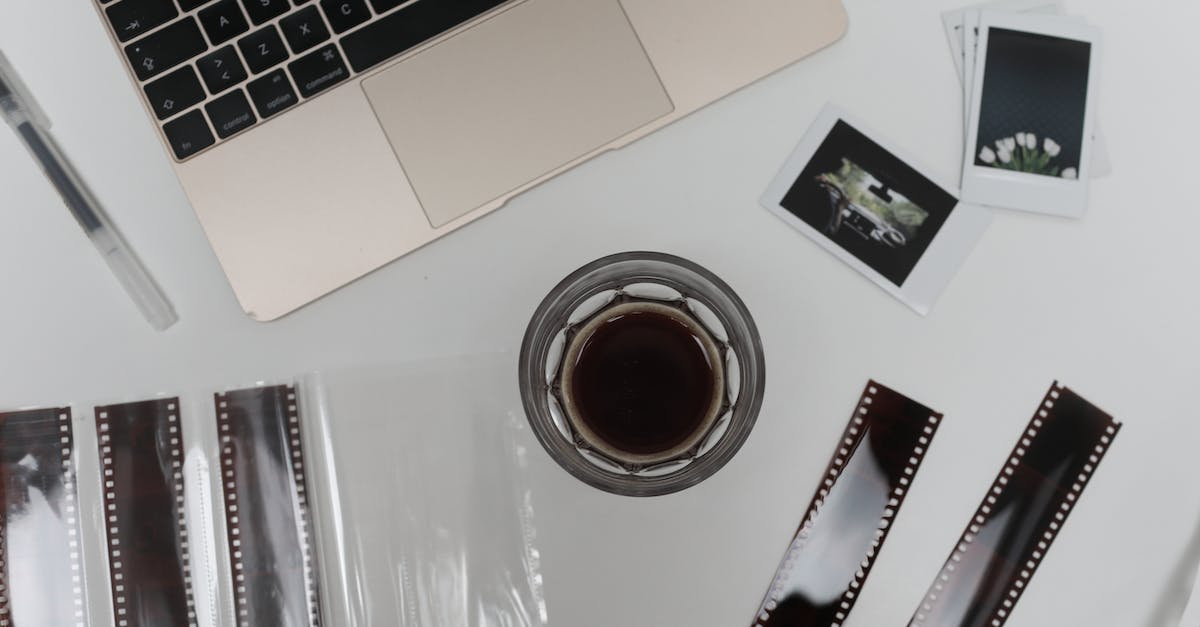 What decreases the negative exp effect on jobs - Top view of coffee cup with vintage instant photos and negative film strips placed on table with opened laptop