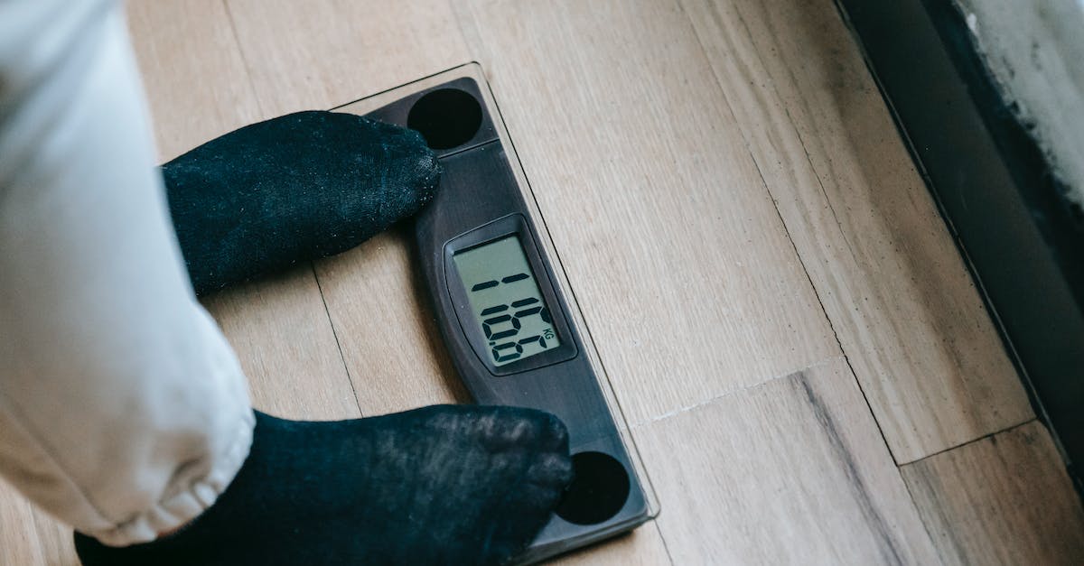 What determines the number of required voters? - From above of unrecognizable person in socks standing on electronic weighing scales while checking weight on parquet during weight loss What determines the number of required voters? - From above of unrecognizable person in socks standing on electronic weighing scales while checking weight on parquet during weight loss