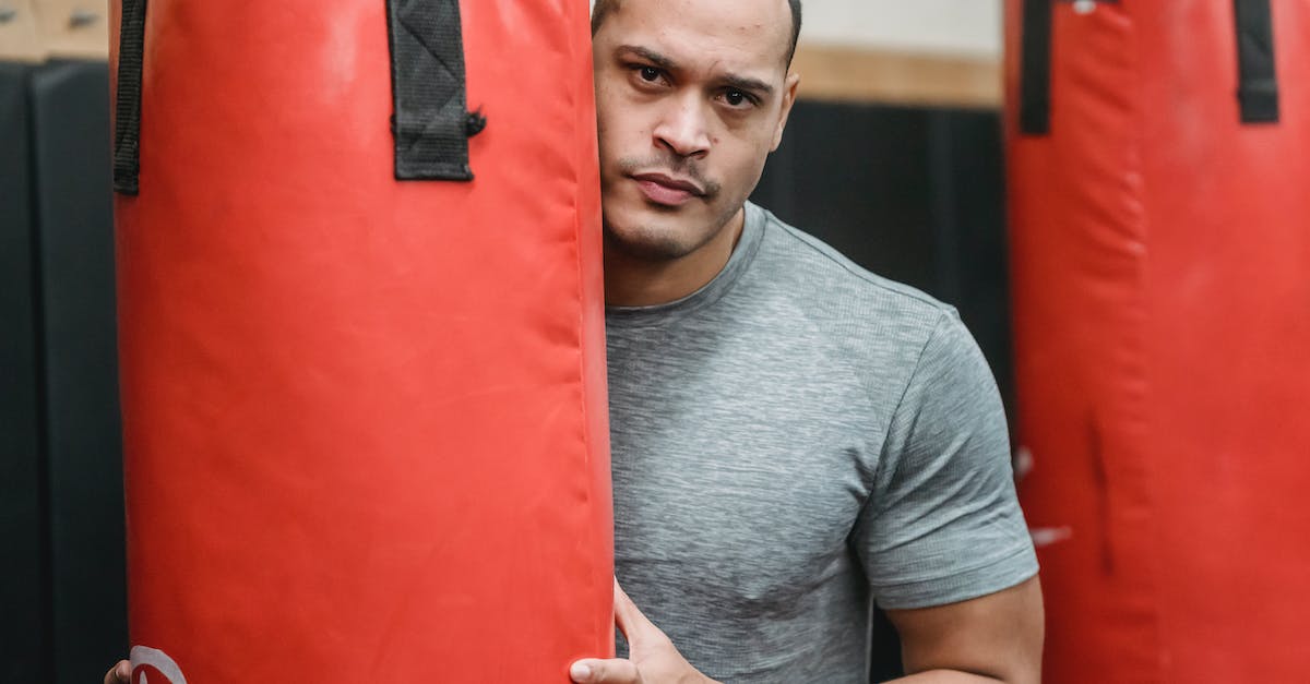 What determines where red phantoms invade (PvP)? - Adult serious ethnic male athlete with muscles in t shirt looking at camera between punching bags in gymnasium