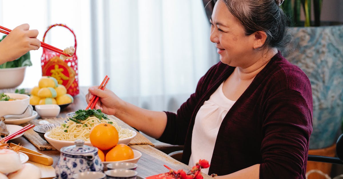 What determines which Mature Content warning Steam gives you? - Cheerful mature ethnic female talking to crop unrecognizable relative at table with delicious noodles during New Year holiday at home What determines which Mature Content warning Steam gives you? - Cheerful mature ethnic female talking to crop unrecognizable relative at table with delicious noodles during New Year holiday at home