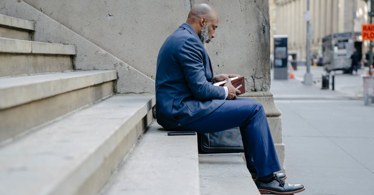 What do crowns above steps mean? - Man in Blue Suit Jacket and Blue Pants Sitting on Concrete Bench