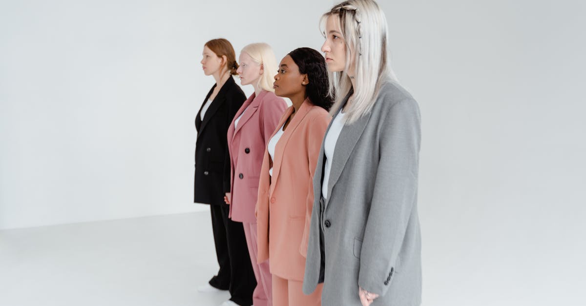 What do different pin colors mean? - Woman in Gray Blazer Standing Beside Woman in Pink Blazer