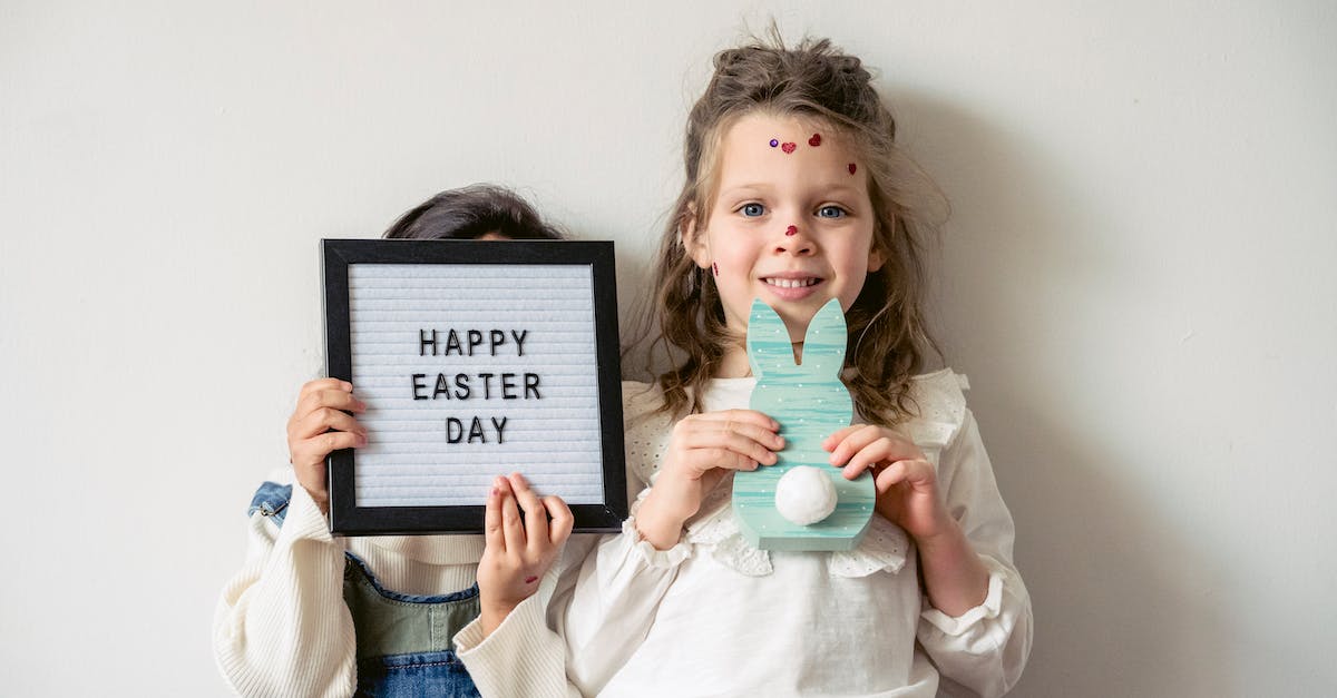 What do i do with rabbit hide - Dolled girl looking at camera while holding wooden green bunny silhouette with friend hiding after Happy Easter card in hands What do i do with rabbit hide - Dolled girl looking at camera while holding wooden green bunny silhouette with friend hiding after Happy Easter card in hands
