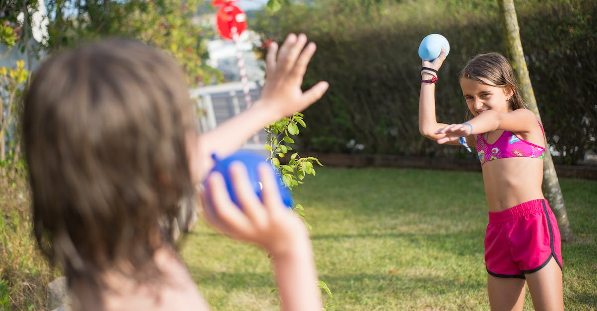 What do I earn for playing on Hard or more? - Woman in Red Tank Top Holding Blue Ball