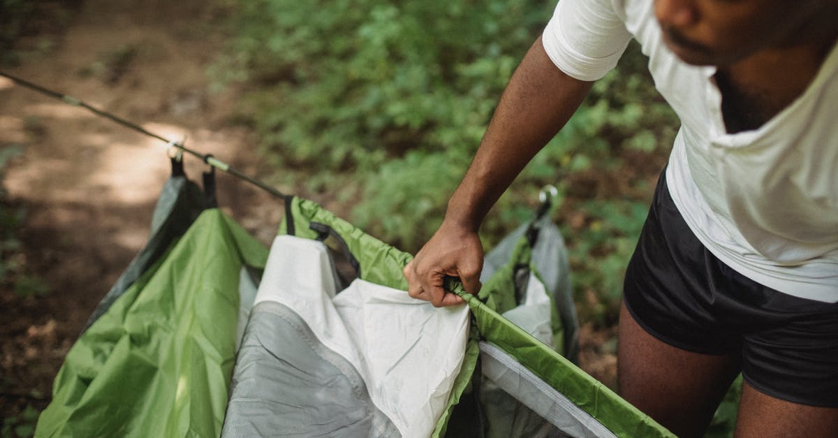 What do I get experience from? - From above of crop African American male tourist preparing for camping in forest while traveling in wildlife What do I get experience from? - From above of crop African American male tourist preparing for camping in forest while traveling in wildlife