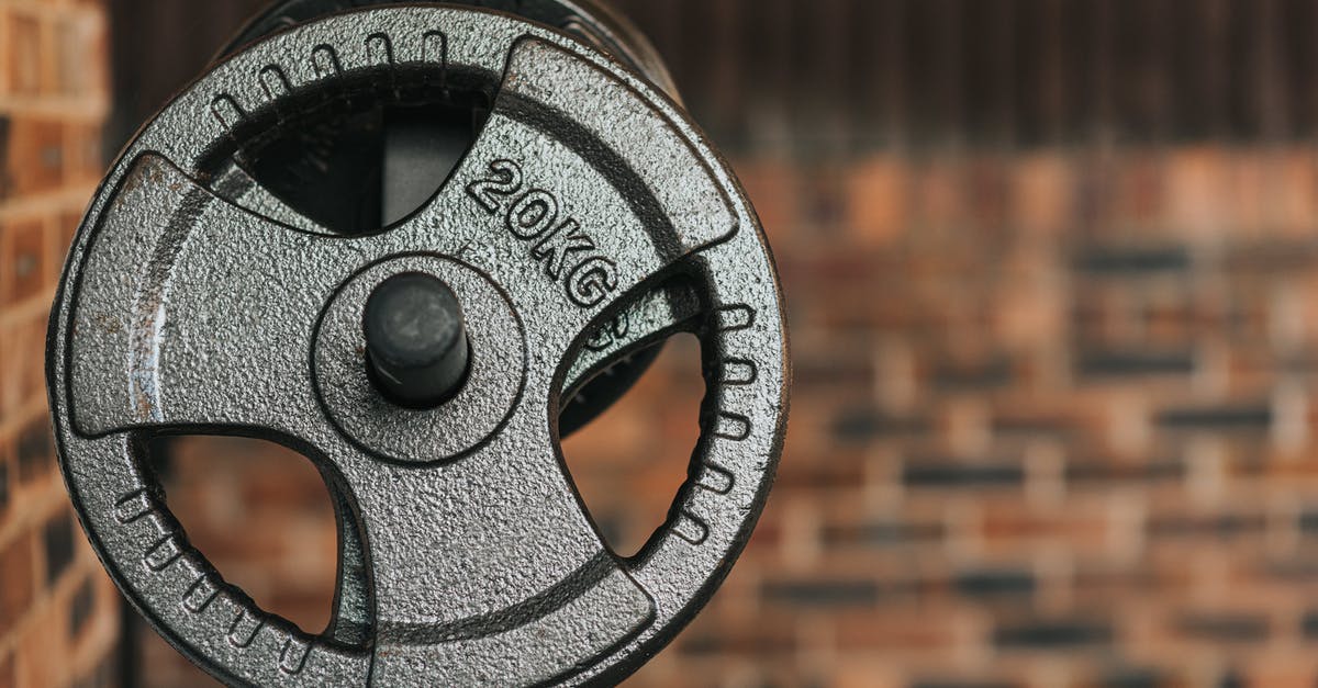 What do the bar colors mean, during gym fight? - Modern black dumbbell with circle shaped plates indicating weight number on solid surface in daylight