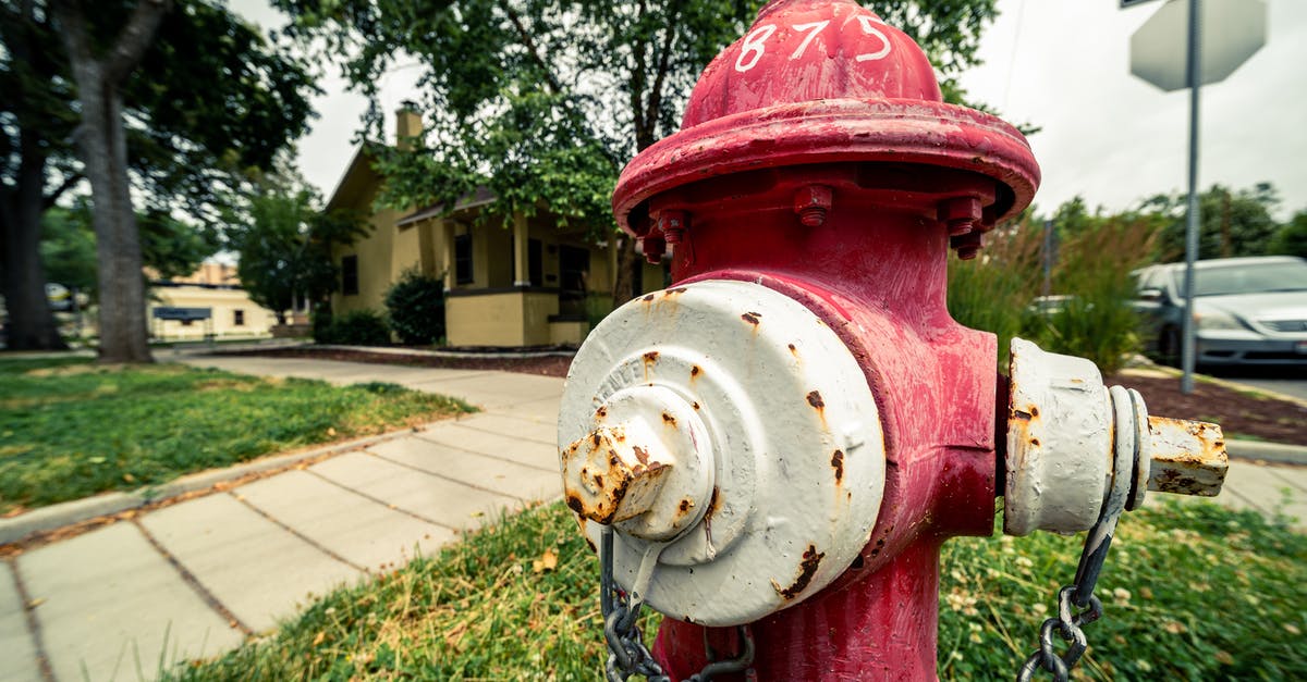 What do the green and red chevron indicators mean? - Old rusty hydrant on grass meadow near house What do the green and red chevron indicators mean? - Old rusty hydrant on grass meadow near house