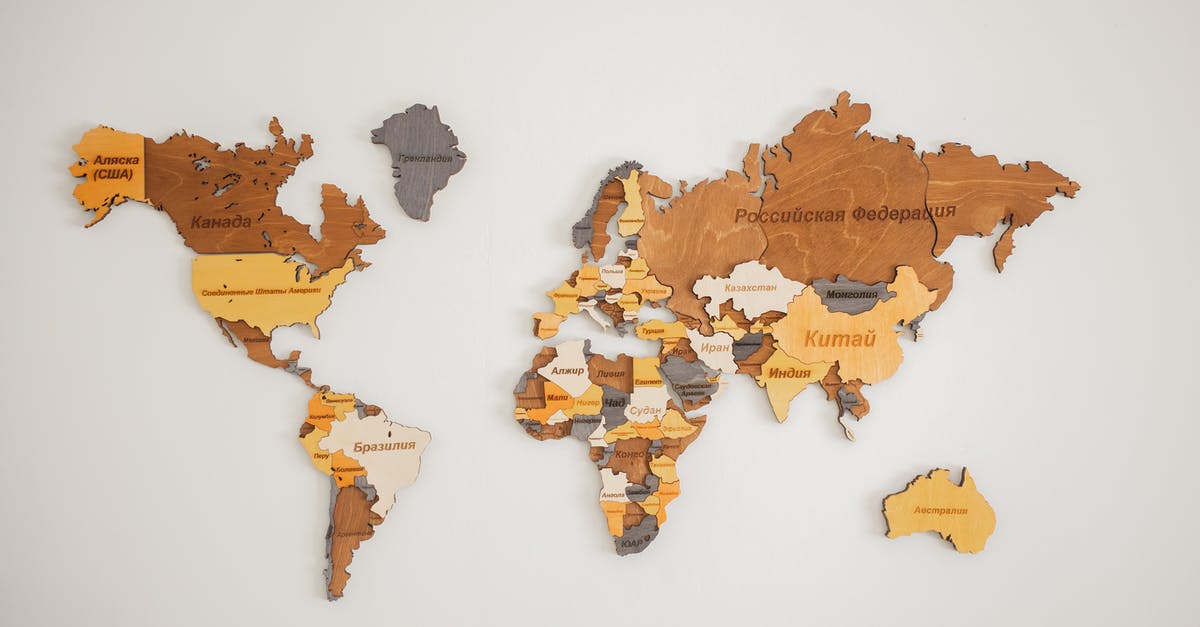 What do these strings below the map names mean? - Decorative creative wooden world continents with country names written in Cyrillic attached on white background in light room of studio