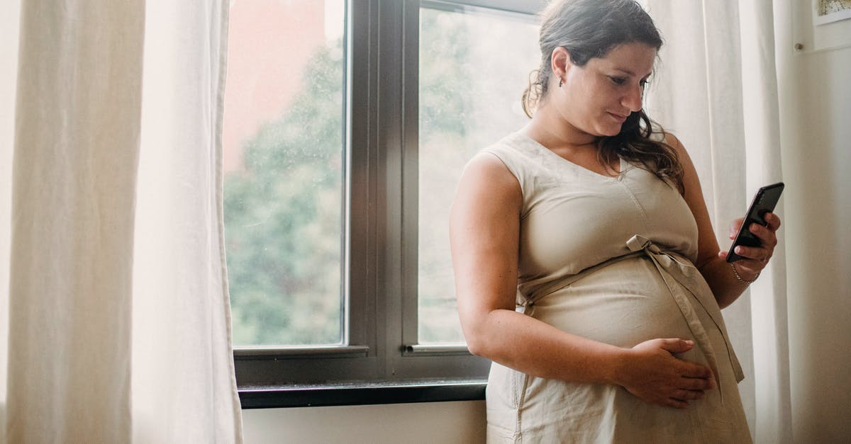 What does a Valve Anti-Cheat (VAC) notification look like? - Pregnant woman using cellphone while standing at home