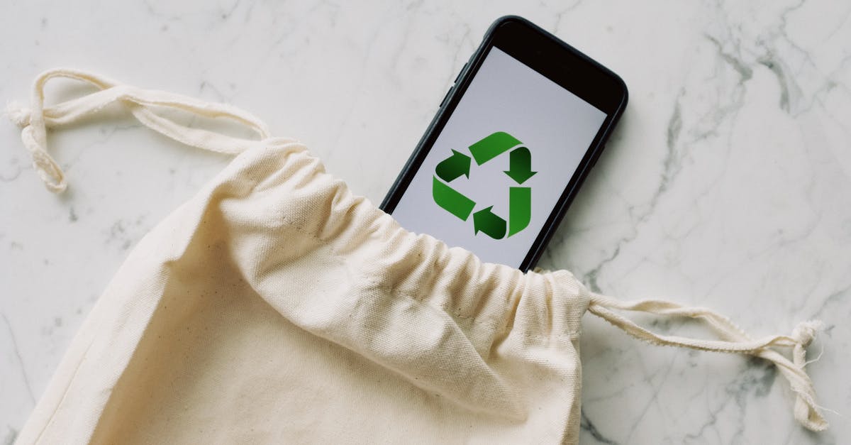 What does a white/yellow rank icon mean - Top view of plain white cotton sack and smartphone with green recycle emblem composed on marble surface