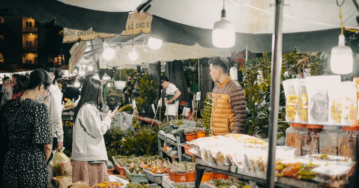 What does buying a wish in Sega's Aladdin do? - A Woman Holding a Cellphone Standing in Front of Food Stall What does buying a wish in Sega's Aladdin do? - A Woman Holding a Cellphone Standing in Front of Food Stall