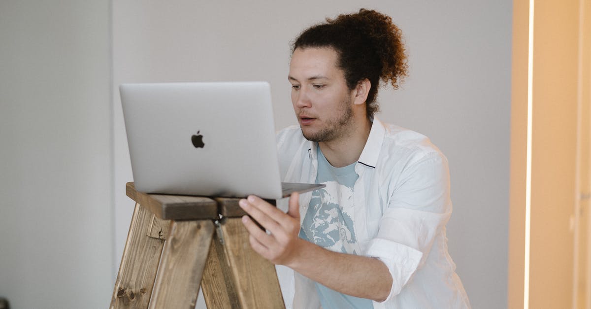 What does IP stand for? - A Man Using a Laptop on a Wooden Stand
