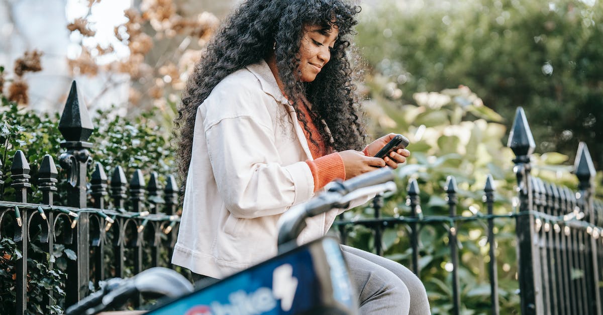 What does it mean for a bike to be inside-drifting versus outside-drifting? - African American female with smartphone sitting on bench near bike