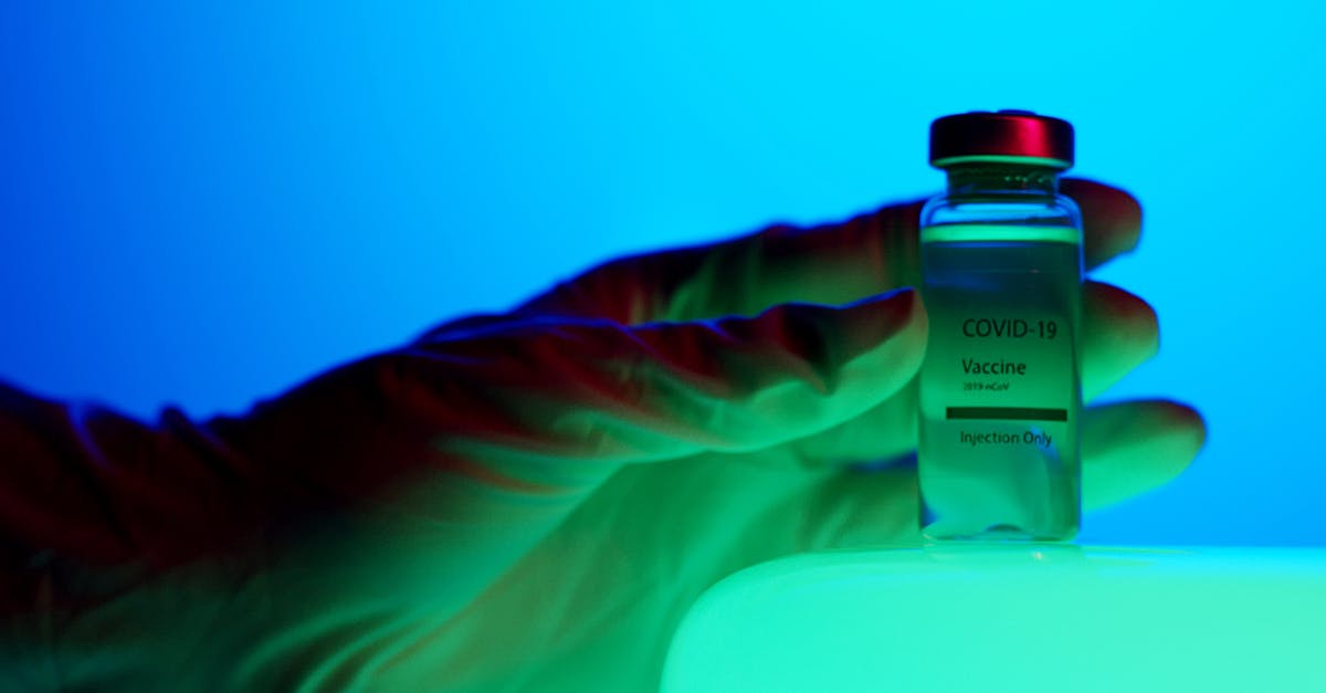 What does it mean when people are shown in green in the hospital? - Close-Up View of a Person Holding a Vaccine Vial