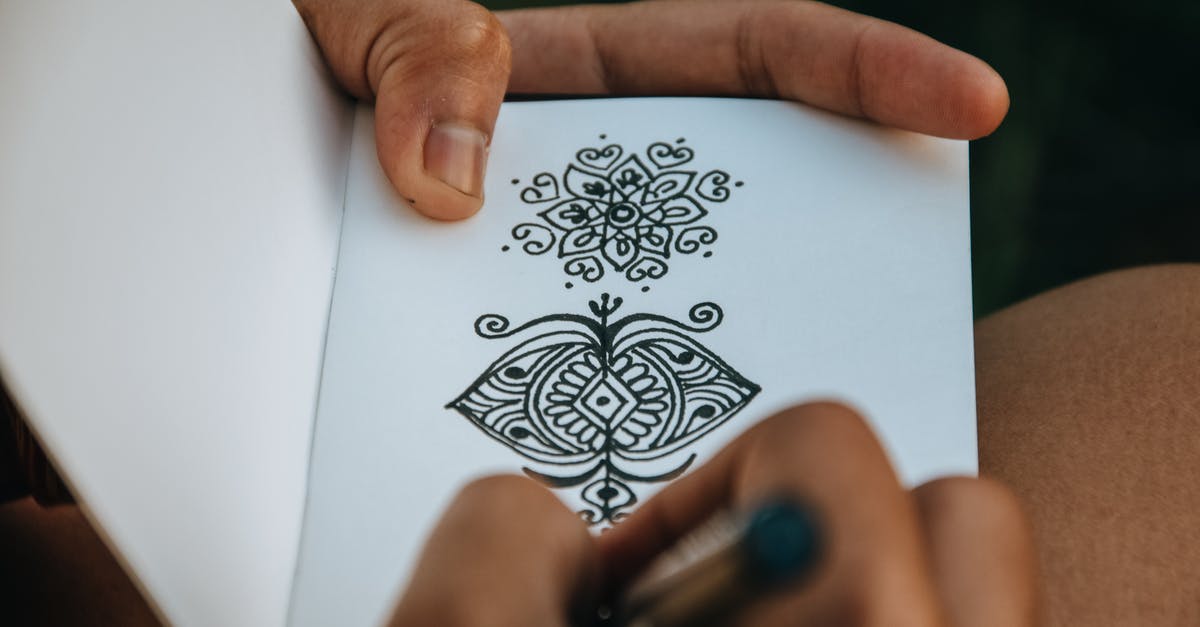 What does negative skill progress mean? - Crop anonymous talented person creating difficult mehendi sketch in album with white sheets