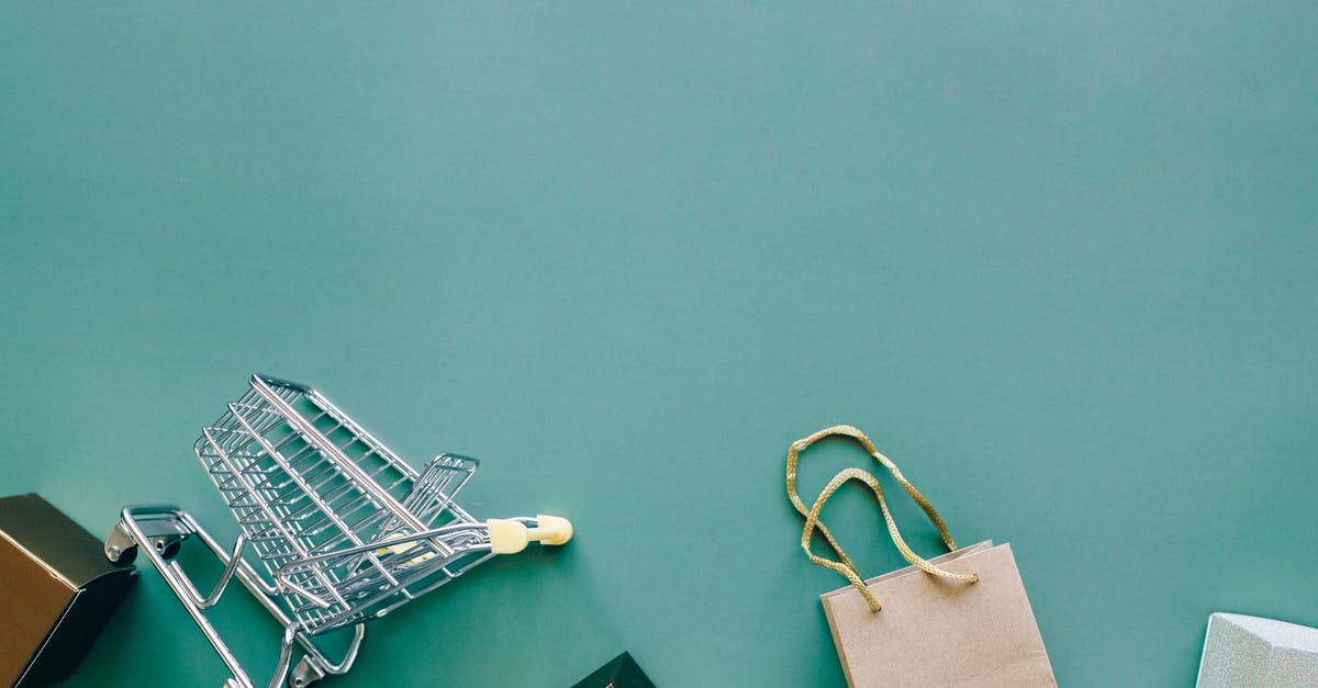 What does "shopping" mean? - Miniature Shopping Cart on Green Background What does "shopping" mean? - Miniature Shopping Cart on Green Background