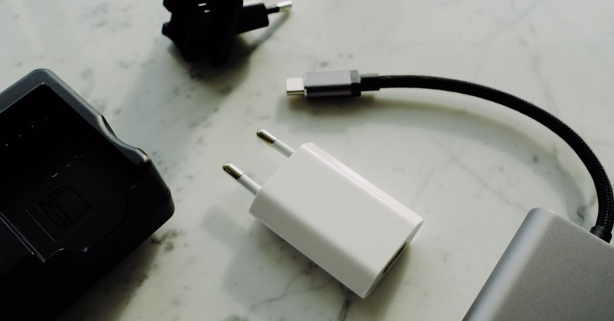 What does small white arrow on battery charge indicator mean? - Composition of various modern electronic devices placed on white marble surface