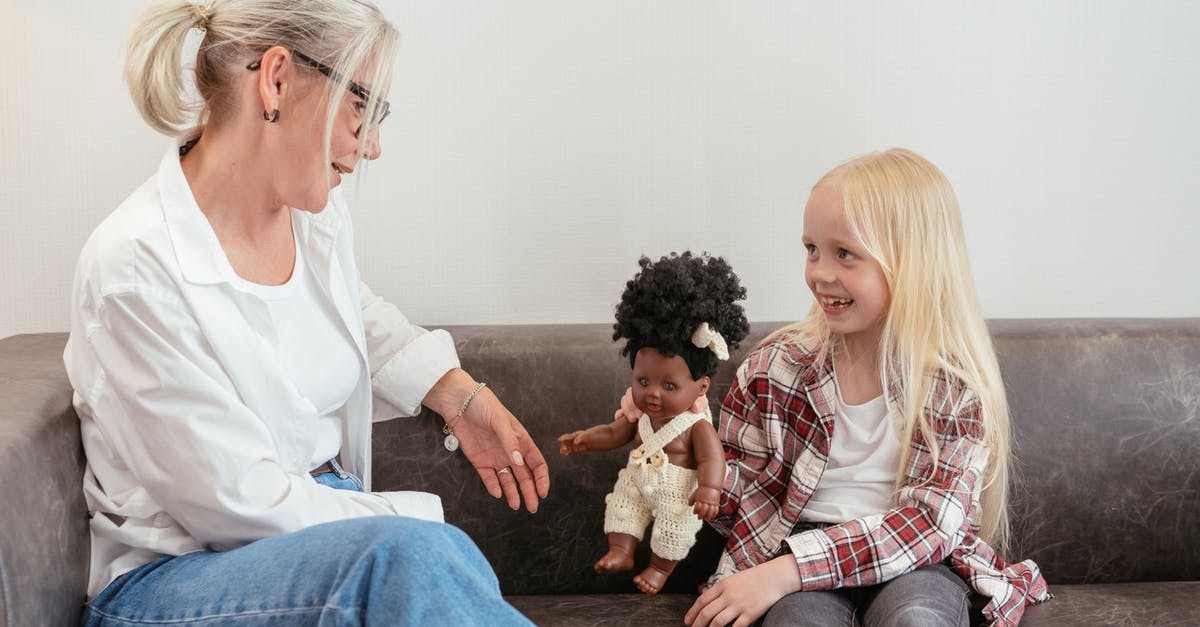 What does the Clothier (or any) voodoo doll do? - Woman in White Long Sleeve Shirt Sitting Beside Girl in White Long Sleeve Shirt