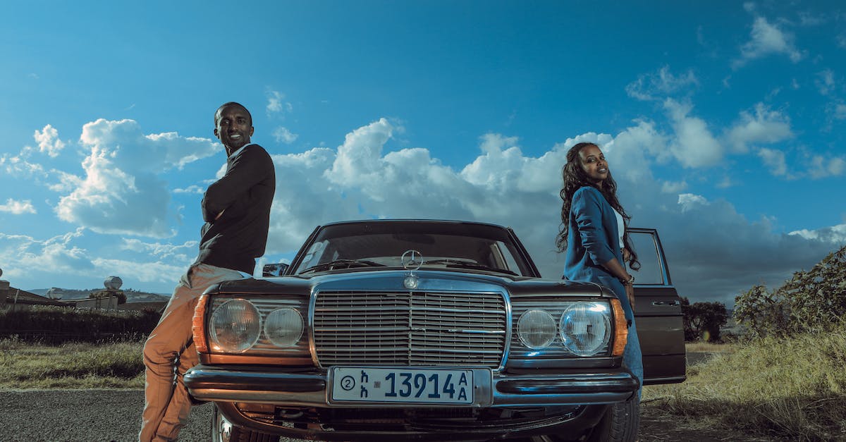 What does the door want from me? - Stylish black couple standing near retro car in countryside