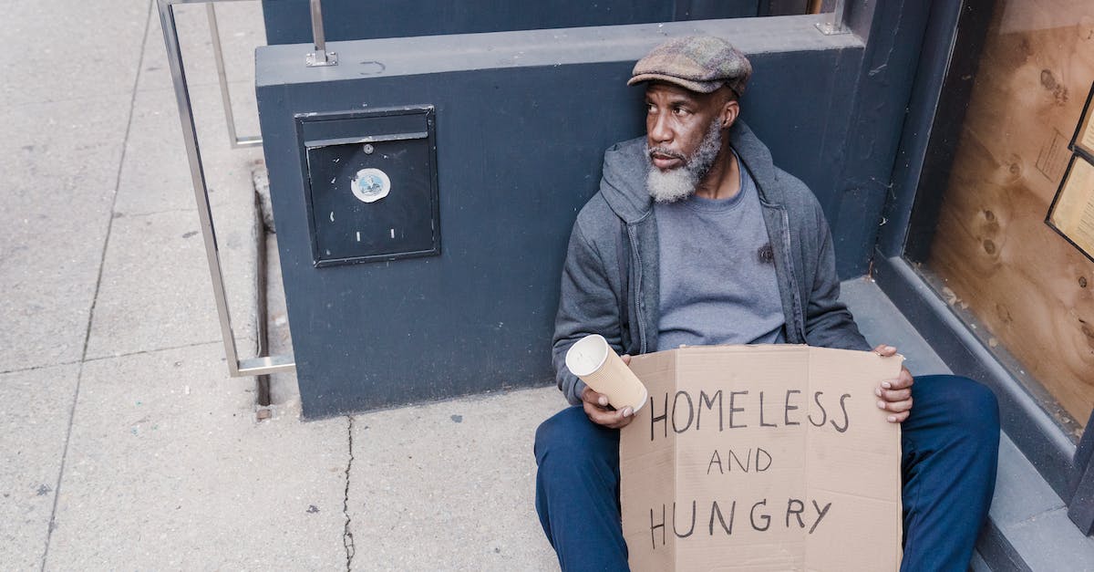 What does the Elder Sign do? - Homeless Man Sitting on the Street Holding a Cup and Sign Board What does the Elder Sign do? - Homeless Man Sitting on the Street Holding a Cup and Sign Board
