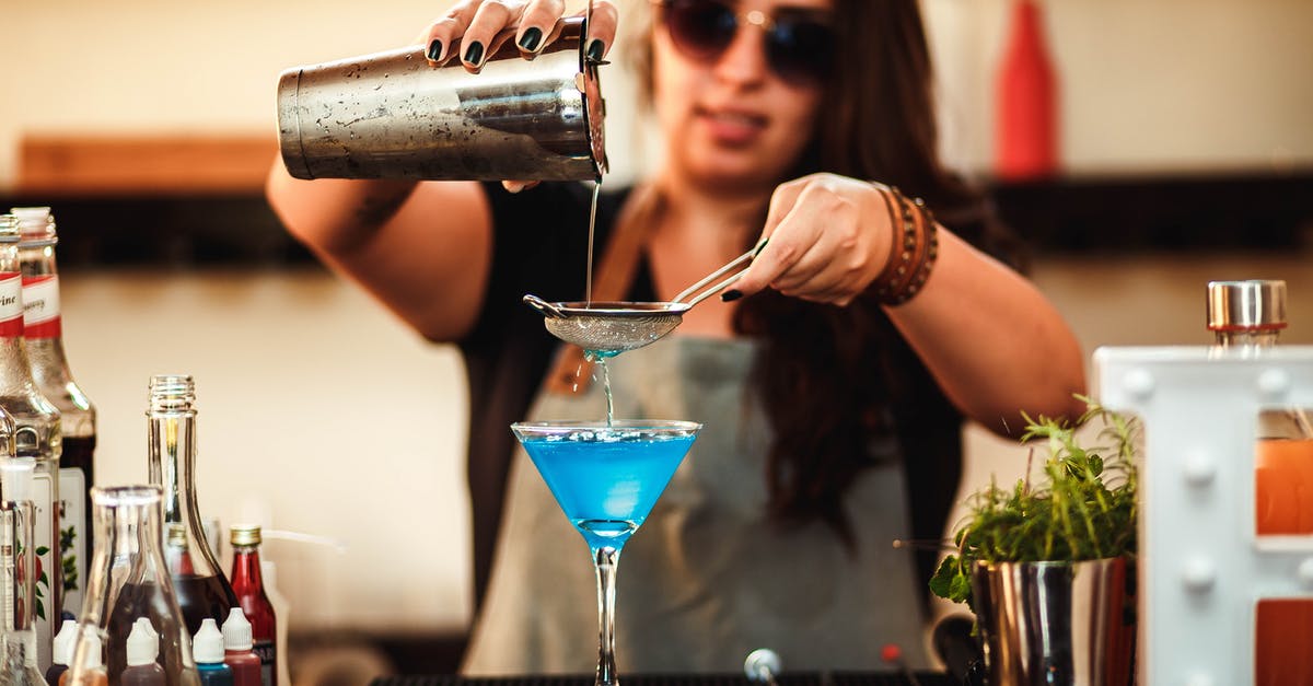 What does the flashing blue portion of the health bar mean? - Blurred stylish woman in sunglasses pouring blue alcoholic drink with strainer into cocktail glass at counter