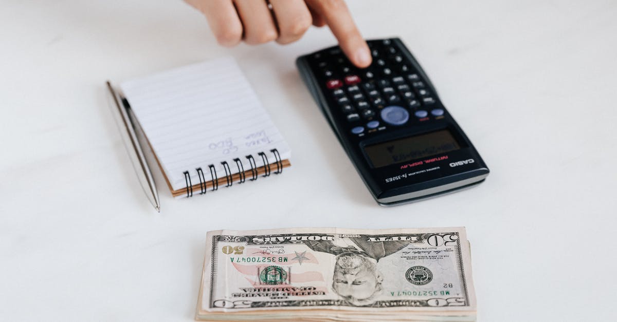 What does the small number when switching characters means? [duplicate] - Top view of crop faceless economist touching calculator button while counting income near heap of paper bills and small notebook with pen