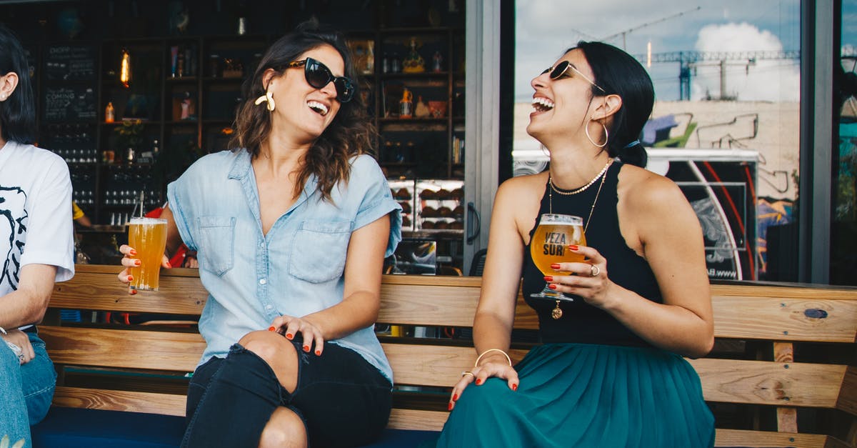 What does the vertical bar on the left mean on words with friends 2? - Two Smiling Women Sitting on Wooden Bench