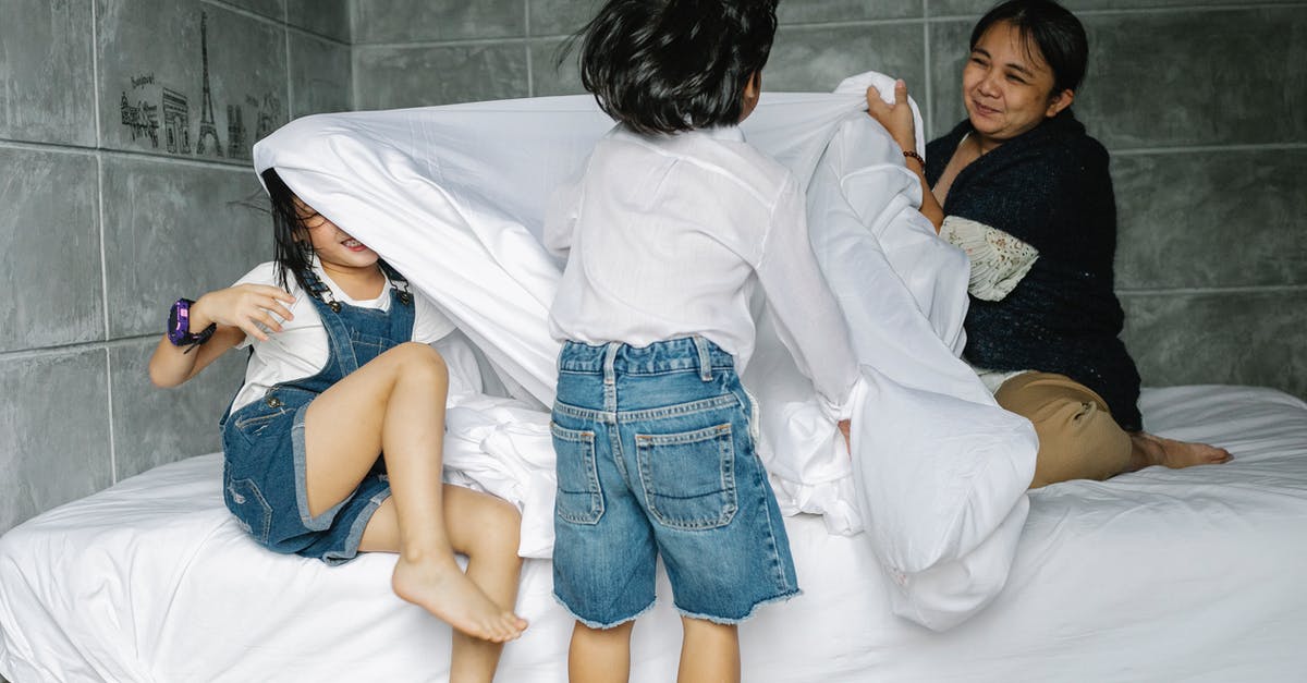 What effect does galaxy age have during game generation? - Cheerful grandmother sitting on comfortable bed and holding blanket while playing with kids at home