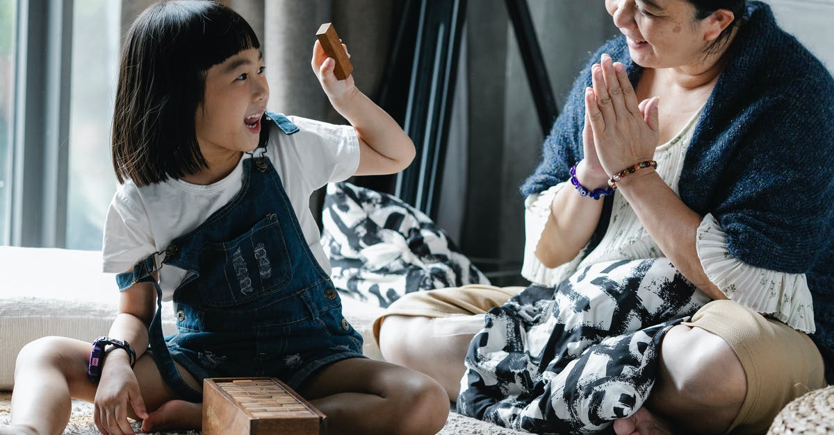 What effect, if any, does "choosing" an enemy strategy have? - Cheerful woman with granddaughter playing tower game at home What effect, if any, does "choosing" an enemy strategy have? - Cheerful woman with granddaughter playing tower game at home