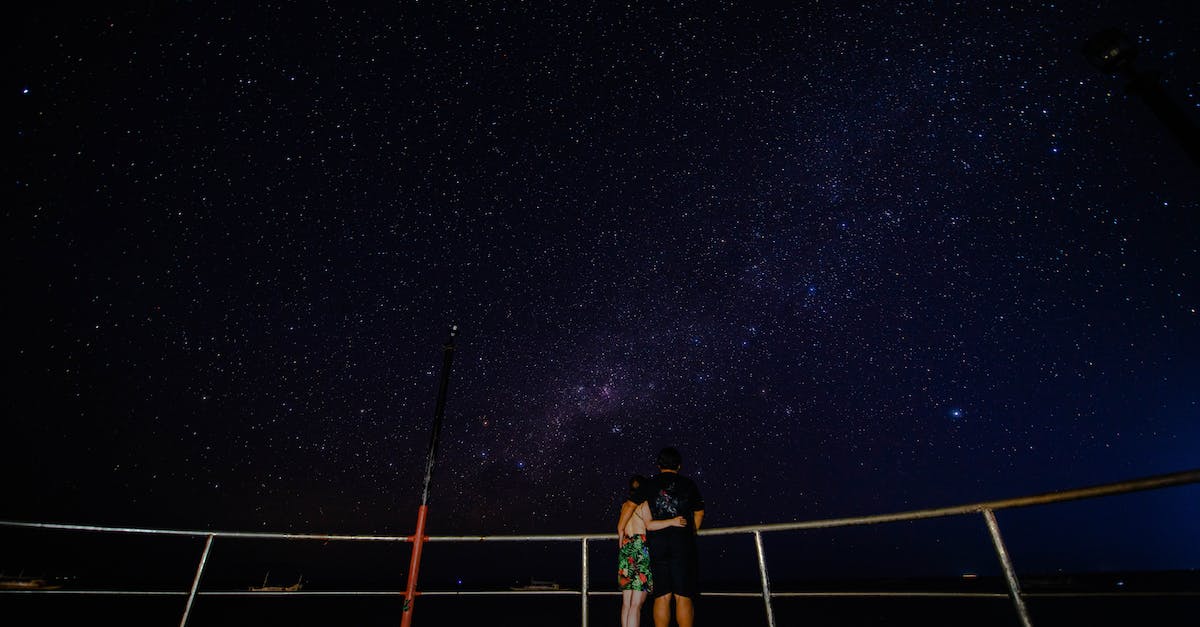 What factors affect the star rating at the end of a level? - Faceless couple on observation platform admiring starry sky at night