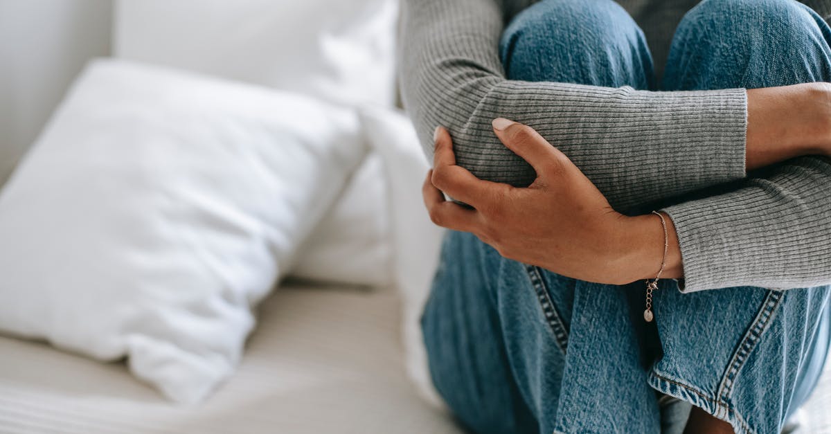 What factors contributed to E.T's reputation as a bad game? - Crop faceless female feeling helpless and frustrated embracing knees while sitting on bed in loneliness What factors contributed to E.T's reputation as a bad game? - Crop faceless female feeling helpless and frustrated embracing knees while sitting on bed in loneliness