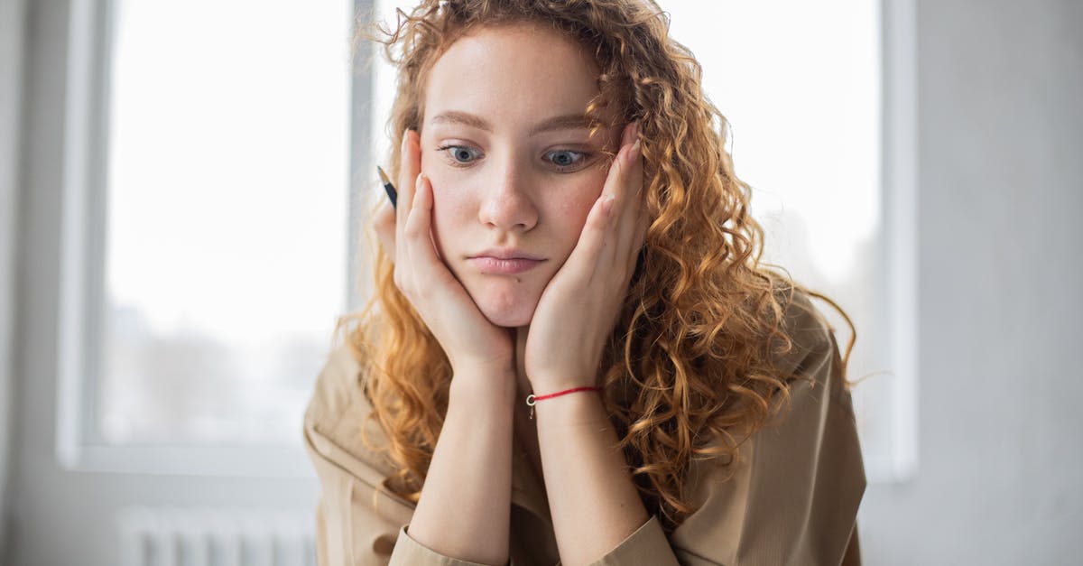 What factors should I consider when comparing 2-Hand to 2x1-hand weapons? - Pensive female student with hands on cheeks looking down while sitting in light room on blurred background while deciding task in frustration