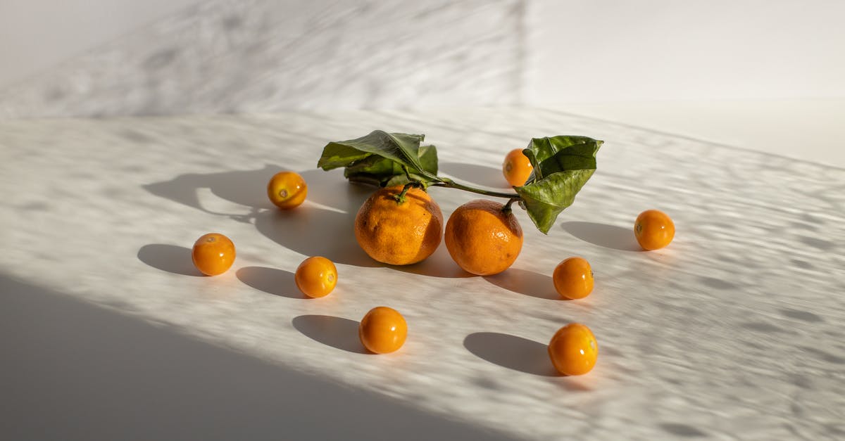 What game is this sprite of a blue-haired character pushing a fruit from? - Healthy tangerines and groundcherries scattered on white surface in daylight What game is this sprite of a blue-haired character pushing a fruit from? - Healthy tangerines and groundcherries scattered on white surface in daylight