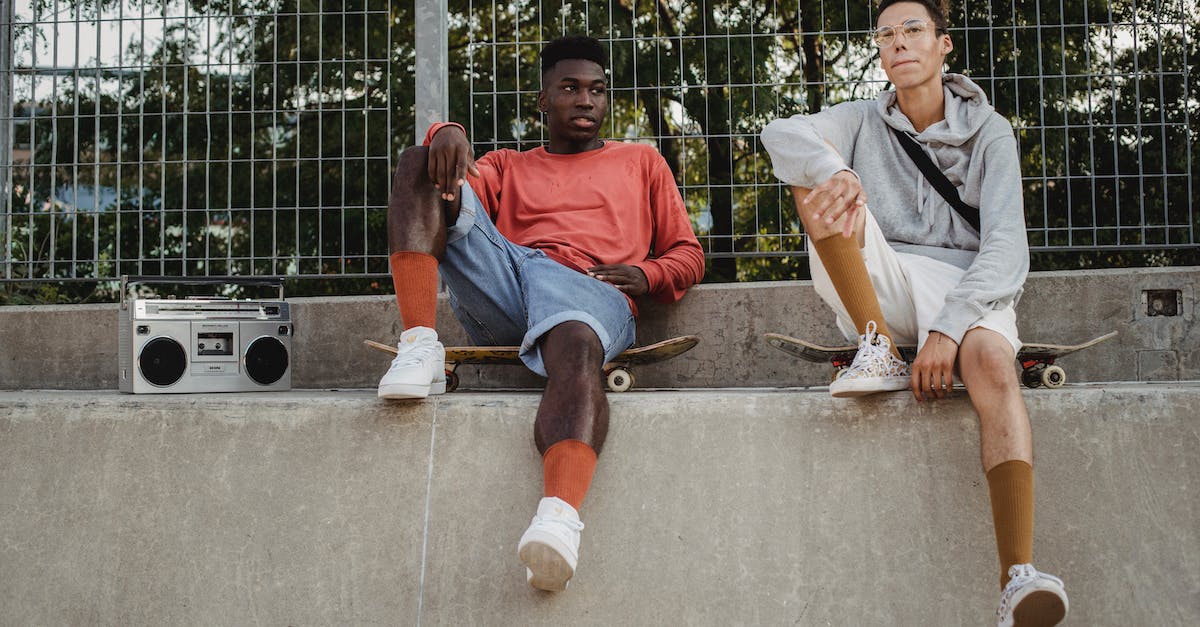What genre is best for a song about shoes? - From below of serious multiracial young friends resting on skateboards and listening to music on vintage boombox in skate park