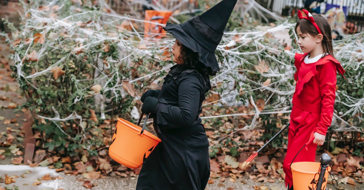 What happens if you give a devil axe to the lumberjack in his side quest? - Side view of children with buckets trick or treating while pretending to be witch and devil strolling on autumn street with Halloween decorations