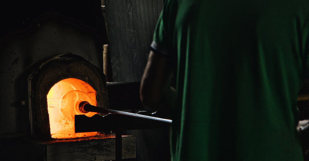 What happens to Mephiles after you defeat Solaris and blow out his flame? - Back view of crop unrecognizable professional worker standing in front of furnace while blowing glass in workshop