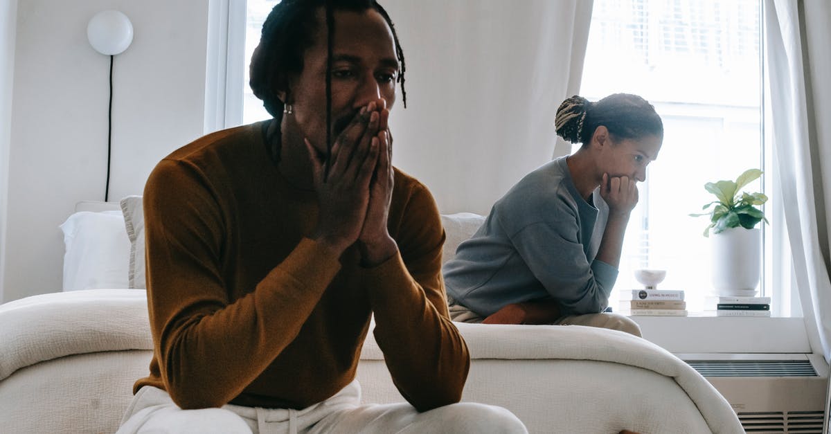 What happens when separate wars with a common enemy end? - Wistful concerned African American couple in casual clothing sitting on bed at home after having quarrel