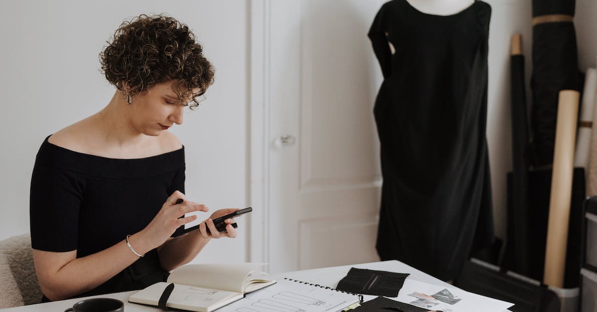 What happens when you're not online and the drafts start? - Focused fashion designer text messaging on smartphone in studio