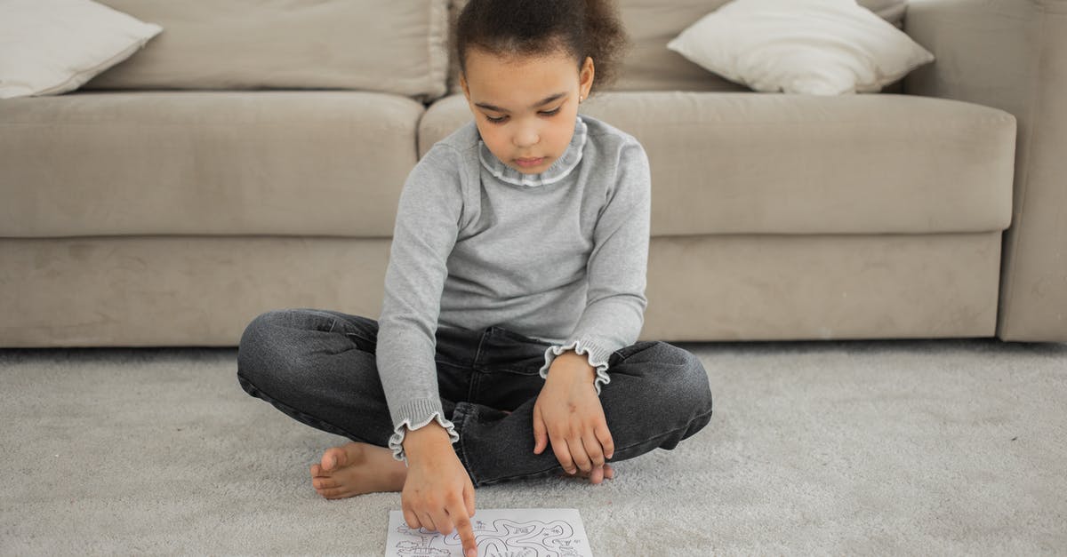 What happens when you solve the second Maze/Tower puzzle? - Full length of barefooted focused little black girl in casual clothes sitting on floor near sofa and solving labyrinth exercise painted on paper What happens when you solve the second Maze/Tower puzzle? - Full length of barefooted focused little black girl in casual clothes sitting on floor near sofa and solving labyrinth exercise painted on paper