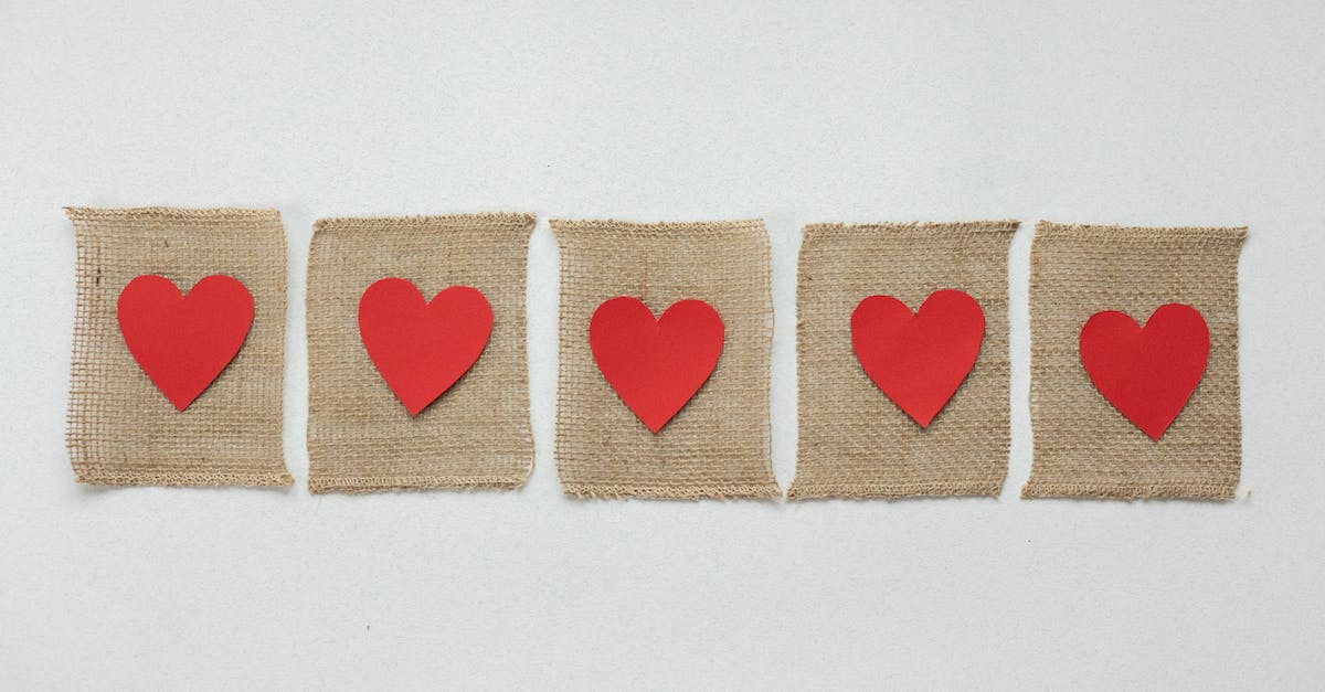 What heart pieces are unavoidable? - From above of handmade burlap pieces of fabric with bright red hearts placed on white background