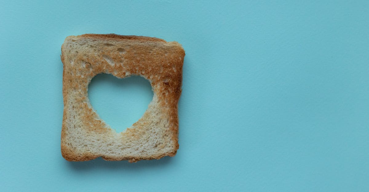 What heart pieces are unavoidable? - Top view of piece of white bread with cut heart on blue background