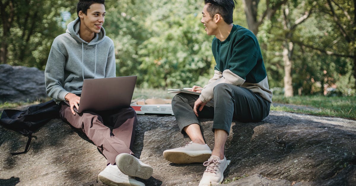 What information gets shared if I connect online? - Full body of positive multiracial classmates sharing information on university assignment while browsing laptop in nature