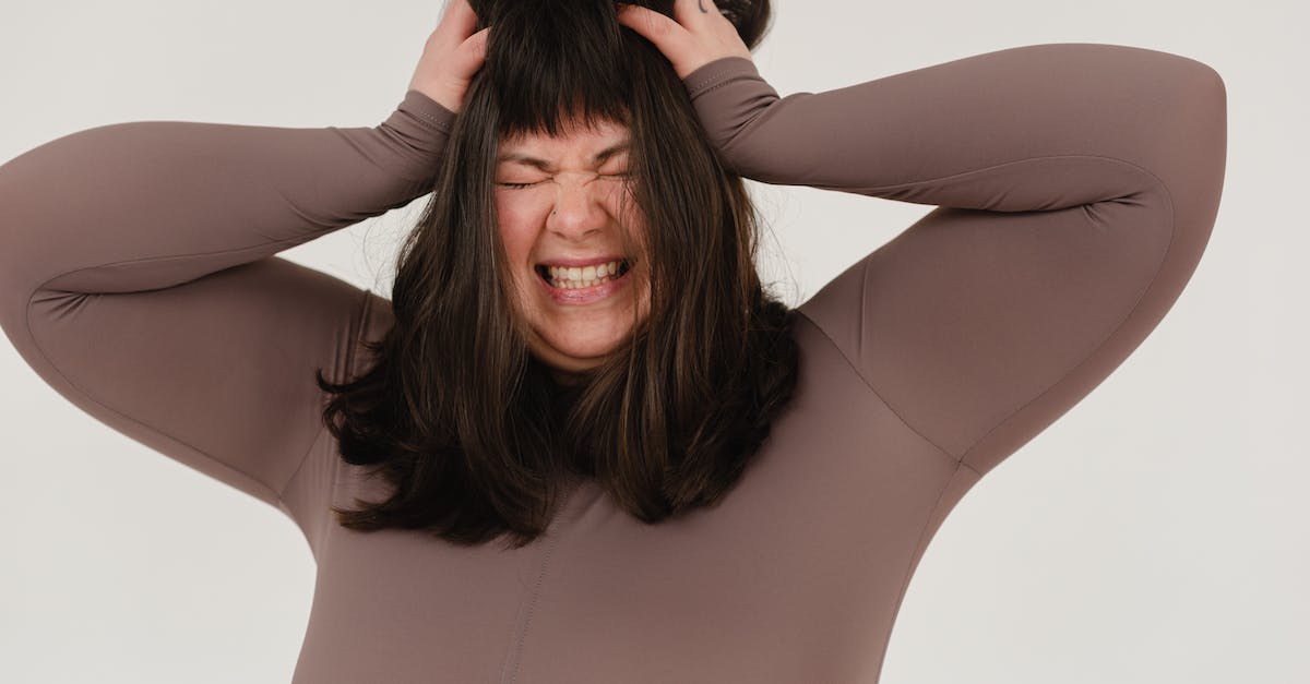 What is a flaccid grab? - Young obese woman rumpling hair with closed eyes in white studio