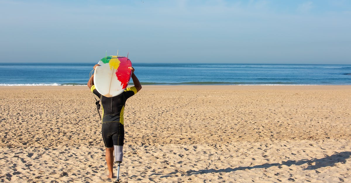 What is called "maximum carry weight" in the formula for strength advancement - Unrecognizable amputee male surfer carrying surfboard on head towards sea