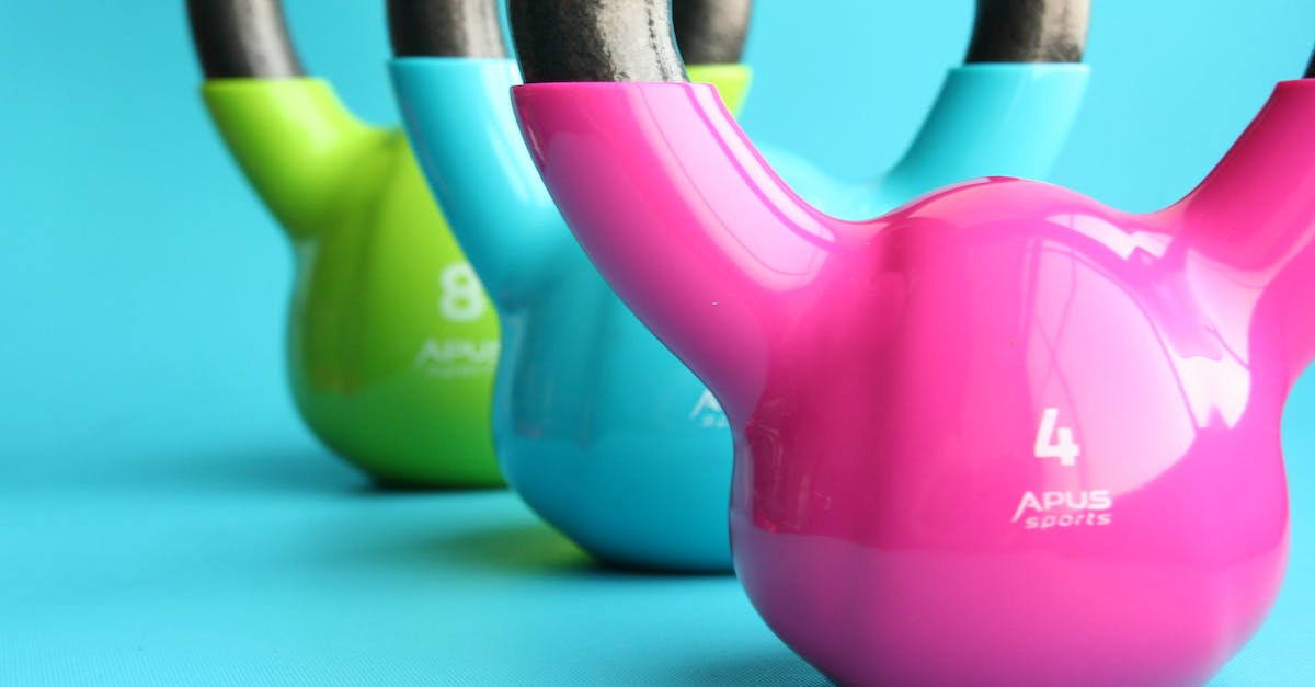 What is called "maximum carry weight" in the formula for strength advancement - Green, Blue, and Pink Kettle Bells on Blue Surface